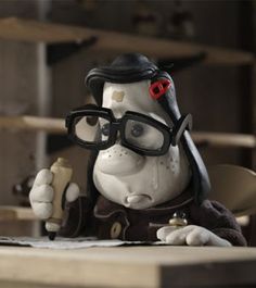 a cartoon character sitting at a desk with glasses on