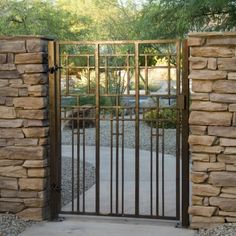 an iron gate is opened to reveal a stone wall