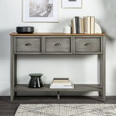 a grey console table with drawers and books on top