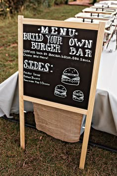 a chalkboard menu sign sitting on top of a table covered in white cloths