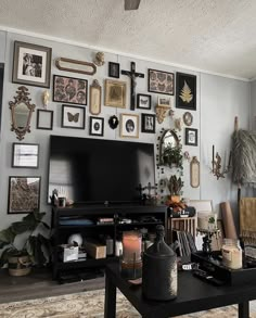 a living room filled with furniture and pictures on the wall next to a flat screen tv