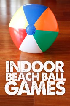 an inflatable beach ball sitting on top of a wooden floor next to the words indoor beach games