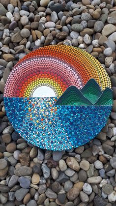 a colorful plate sitting on top of a pile of rocks