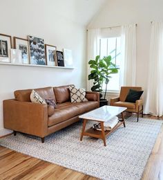 a living room filled with furniture and pictures on the wall