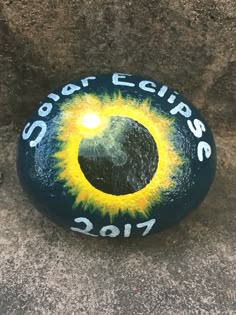 a painted rock with the words solar eclipses on it and an eyeball in the center