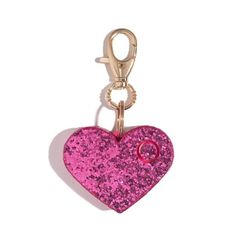 a pink heart shaped keychain hanging from a metal hook on a white background