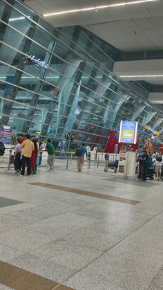 people are standing in an airport waiting for their luggage to arrive or leave the terminal