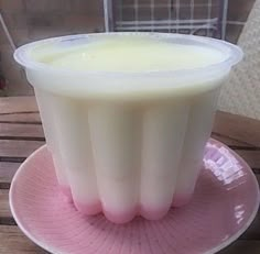 a cup filled with liquid sitting on top of a pink saucer