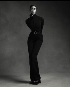 a black and white photo of a woman in high heeled shoes with her hands on her hips