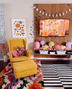 a living room filled with lots of furniture and colorful decorations on the wall next to a window