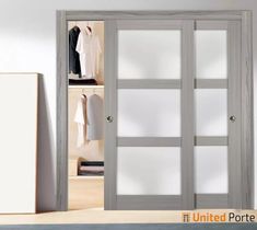 an open closet with white doors and clothes on hangers next to it in a room