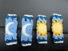 three crocheted sunflowers sitting on top of a car seat next to each other