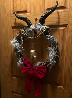 a wreath with horns and bells hanging on a door