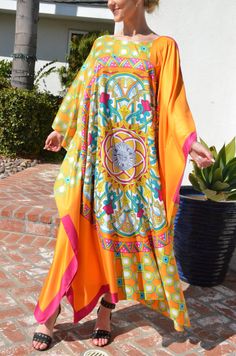 Make your day shine in this gorgeous, designer print silk caftan. Vibrant colors of orange, fuchsia and greens in a unique and special combinations of patterns with hints of gold embellishment throughout the pattern. A stunning garment for any occasion. Opaque fabric with no need of undergarment. One size. Fits medium to X-Large . Can be worn by many sizes. The width is 54 inches wide, edge to edge, or 108 inches around the body. The length is 52 inches. The side seams are 7 inches from the edge Silk Multicolor Kaftan For Eid, Multicolor Silk Kaftan For Eid, Silk Digital Print Festival Kaftan, Orange Kaftan With Kimono Sleeves For Spring, Orange Spring Kaftan With Kimono Sleeves, Orange Printed Maxi Dress Beach Cover-up, Silk Bohemian Maxi Dress For Eid, Bohemian Silk Maxi Dress For Eid, Orange Silk Dress For Eid