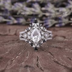 an engagement ring is shown on top of a table with flowers in the back ground