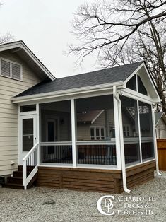 a small house with screened porch and white siding