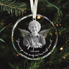 a glass ornament with an image of a woman on it hanging from a christmas tree