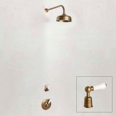 the brass faucet and shower head are shown in this bathroom setting with white walls