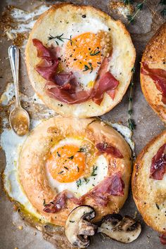 three different types of bread with eggs and bacon in them on a baking sheet next to mushrooms