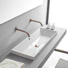 a white bathroom sink sitting under a mirror