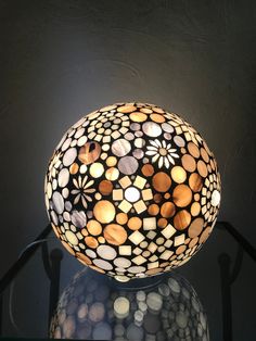 a lamp that is sitting on top of a glass table with a reflection in it