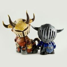 two toy figurines with horns on their heads and armor around them, facing each other