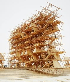 a large wooden structure sitting on top of a sandy beach