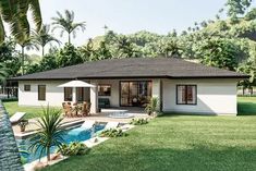 a white house with a pool in the front yard and palm trees around it's edge