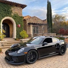 a black sports car parked in front of a house