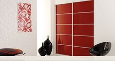 two black and red vases sitting on top of a table next to a white wall