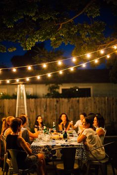 a group of people sitting around a table at night