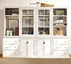 a white china cabinet with glass doors and drawers