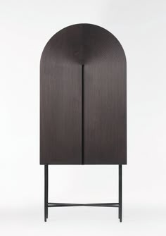 a black cabinet with an arched design on the top and bottom, against a white background