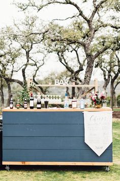 an outdoor bar set up with bottles and flowers