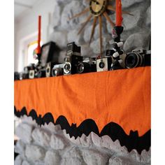 an orange and black halloween mantle with cameras on it