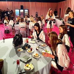 a group of women sitting around a table eating food