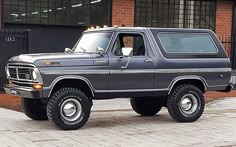 a large gray truck parked in front of a brick building