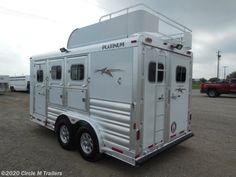 a white horse trailer parked in a parking lot