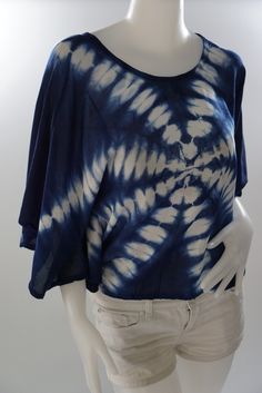 a white mannequin wearing a blue and white tie - dyed shirt with short sleeves