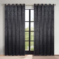 an open window with black curtains in front of it