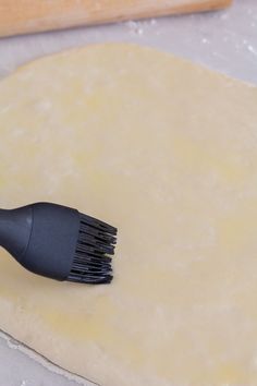 a black brush is on top of some dough