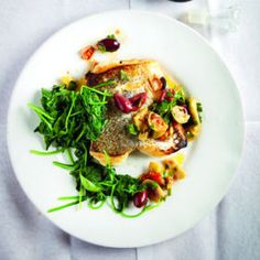 a white plate topped with fish and veggies