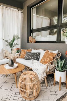 a living room with wicker furniture and potted plants