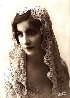 an old black and white photo of a woman wearing a veil