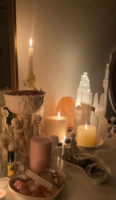 candles and other items on a table in front of a mirror