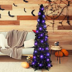 a living room decorated for halloween with purple lights and bats on the wall behind it