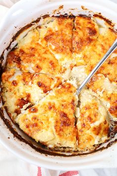 a white dish with some food in it and a fork sticking out of the top