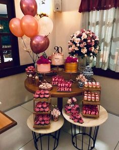 a table topped with lots of cakes and cupcakes