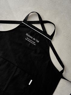 a black apron with white writing on it