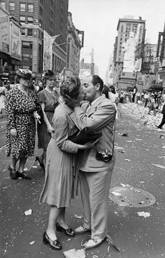 a man and woman kissing in the middle of a street with confetti all over them